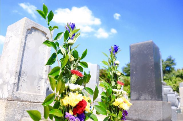 青空と墓に供えられた花